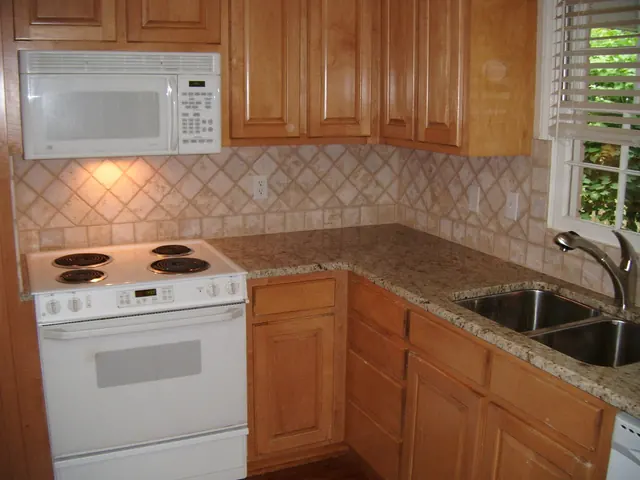 Bancada de granito Amarelo Ornamental com cuba dupla de inox: cozinha em l com cooktop