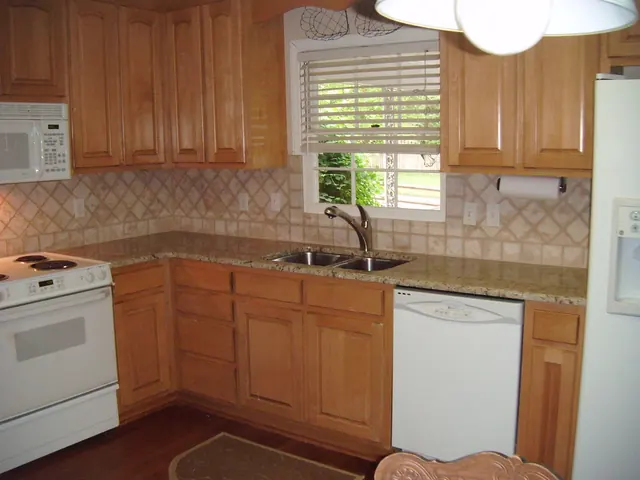 Bancada de granito Amarelo Ornamental com cuba dupla de inox: bancada com cuba sob a janela